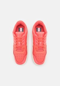 Korallfärgade sneakers med en mjuk syntetisk ovandel, med snörning, perforerad tåbox och en kontrasterande logotype på tungan.