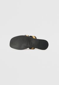 Svart og beige vevde sandaler med flat svart såle. Har svarte stropper med en teksturert finish og en myk, polstret såle.