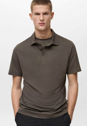 Polo shirt verde oliva scuro con maniche corte, colletto classico e patta con tre bottoni. Texture liscia, design aderente e accessori minimi.