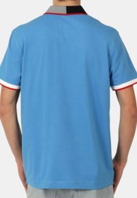 Polo shirt azzurro chiaro con colletto in contrasto grigio e nero, accenti rossi e bianchi sulle maniche e una vestibilità comoda.