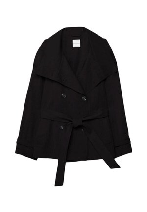 Črni dvovrstni trenč plašč s širokimi ovratniki in usklajenim pasom iz iste tkanine, zavezanim v pasu.