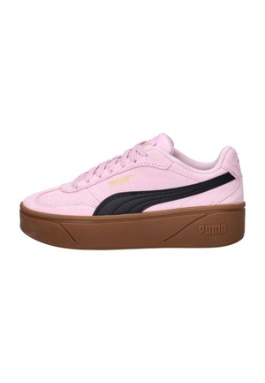 Baskets Puma en daim rose avec semelle épaisse marron, détail rayé noir sur le côté, lacets plats et logo Puma embossé.