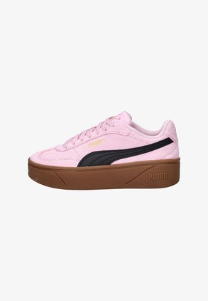 Baskets Puma en daim rose avec semelle épaisse marron, détail rayé noir sur le côté, lacets plats et logo Puma embossé.