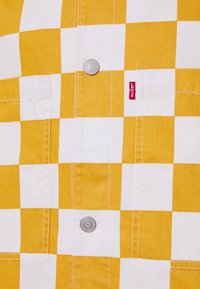 Rumena in bela karirasta srajca z srebrnimi gumbi, našitimi žepi in rdečo oznako Levi's na strani. Bombažna tkanina z gladko teksturo.