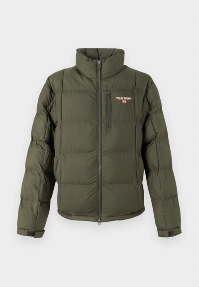 Casaco puffer verde oliva com gola alta, fecho éclair na frente e um bolso no peito. Apresenta uma textura acolchoada e o logótipo 'POLO SPORT'.