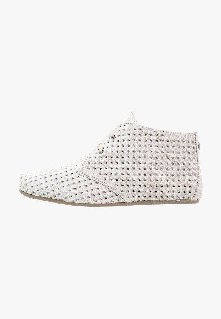 Chaussure beige clair montant à la cheville avec un design perforé, deux œillets pour les lacets et une semelle plate, vue de profil droit.