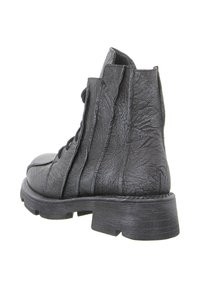 Schwarze Stiefeletten aus strukturiertem synthetischem Material, mit einem mehrlagigen Design, rundem Zehenbereich und dicker Gummisohle mit horizontalen Rillen.