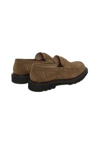 Pruunid seemisnahast mokassiinid musta tüse kummitaldaga, nähtava õmblusega ja penny-riba detailiga valgel taustal.