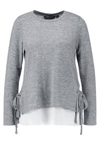 Szary top z długim rękawem, wykonany z teksturowanej dzianiny, z wiązaniami po bokach i białą dolną warstwą, która tworzy efekt warstwowy. Projekt z okrągłym dekoltem.