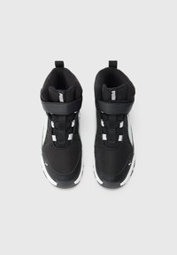 Ett par svarta och vita Puma träningssneakers med hög topp, kardborreband och vadderad innersula på en neutral bakgrund.