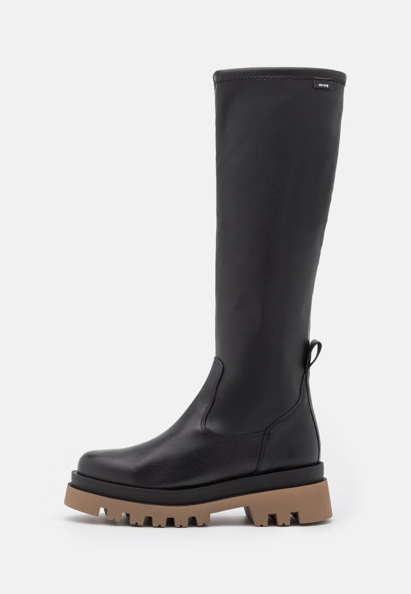Bottes en cuir noir montantes aux genoux avec une semelle épaisse marron, un bout arrondi et une languette à l'arrière. Texture lisse avec des coutures minimales.