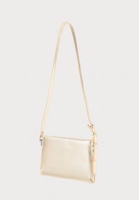 Piccola borsa a tracolla rettangolare beige in pelle con tracolla regolabile appesa su uno sfondo bianco.