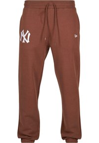 Brune joggebukser med elastisk midje, justerbar snor, og hvit brodert logo på venstre lår. Myk bomullsblanding.