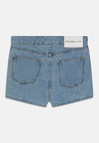 Světle modré džínové šortky s roztřepeným lemem, dvěma zadními kapsami a bílou štítkem Calvin Klein Jeans na pásku.