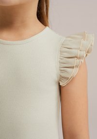 Ljust grön ribbad topp med korta volangärmar och rund halsringning. Mjuk textur med subtil lyster, inga synliga detaljer eller mönster.