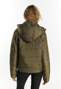 Giacca imbottita verde oliva con cappuccio, caratterizzata da cuciture orizzontali e polsini elastici, realizzata in materiale liscio e leggero.