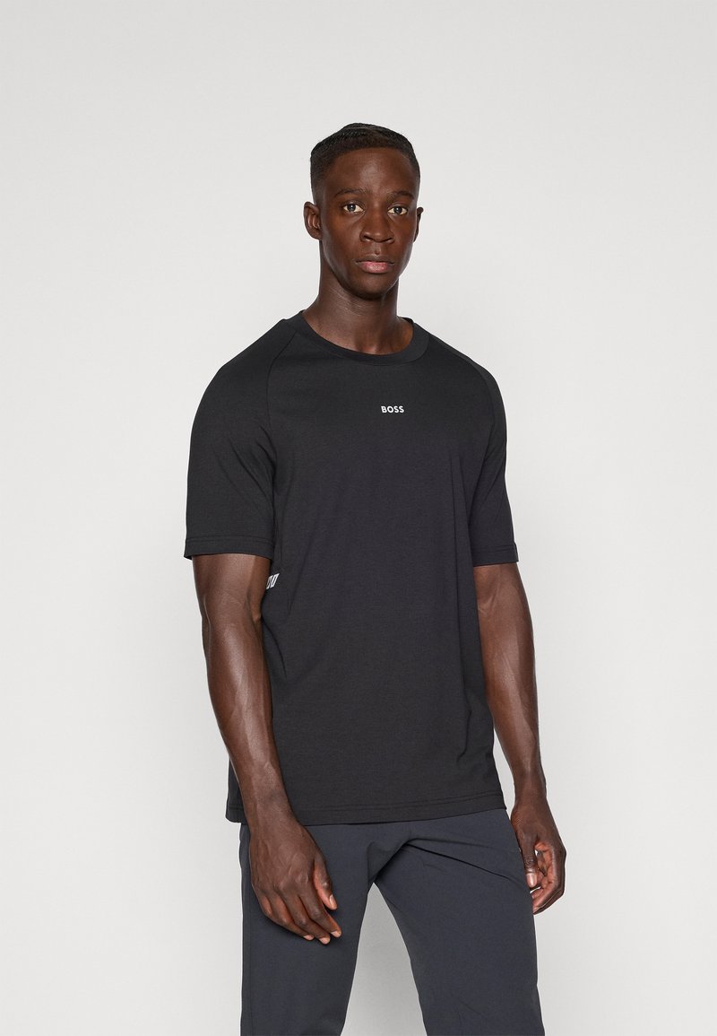 Camiseta atlética negra de manga corta, con escote redondeado y un pequeño logo blanco "BOSS" en el pecho. Tejido suave, corte regular.