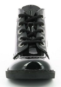 Bottes chevilles noires en cuir verni avec un bout arrondi, œillets blancs et lacets noirs. Semelle en caoutchouc plate avec un profil de traction minimal.