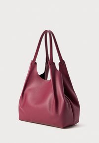 Pruimenleren tote bag met een zachte, textuurachtige oppervlakte; heeft twee lange handvatten en een minimalistische, slungelige vorm.