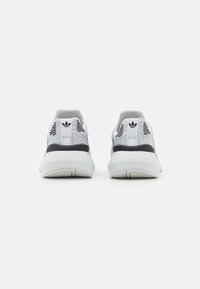 Sneakers con una toma grigia in rete e accenti neri, rinforzo sul tallone e suola bianca. Design testurizzato con dettagli a tre strisce.