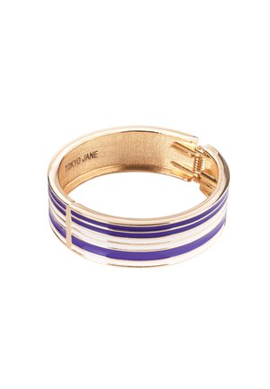 Gold-tone bangle with purple and white enamel stripes. Features a smooth finish and a hinge closure. Engraved "TOKYO JANE" inside.