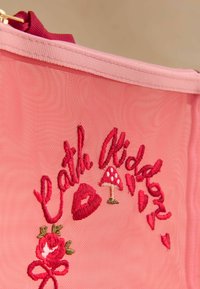 Pouch din plasă roz cu text brodat "Cath Kidston", o trandafir roșu, o ciupercă și detalii în formă de inimă. Are o închidere cu fermoar și o curea din material.