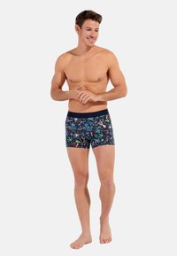 Bóxer para hombres con un fondo azul marino y vibrantes patrones de flores e insectos. Tela suave con una cinturilla elástica para mayor comodidad.