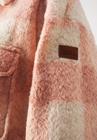 Veste en laine à carreaux rose pâle et crème avec une poche poitrine et une étiquette de marque en cuir marron "ROXY".