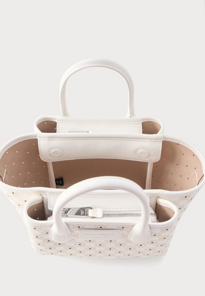 Λευκή δερμάτινη τσάντα ώμου με διάτρητο μοτίβο σε σχήμα διαμαντιού, χειρολαβές στην κορυφή, κλείσιμο με κουμπί και εσωτερική τσέπη με φερμουάρ ορατή από πάνω.