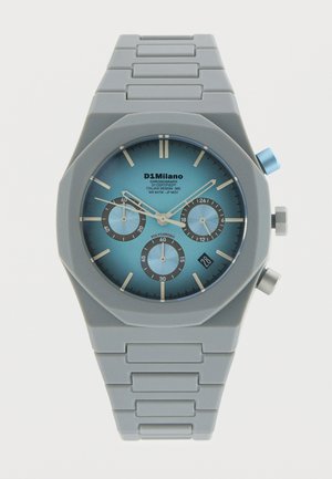 Ceas cu curea metalică gri, cadran albastru, trei subcadrane, fereastră pentru dată la ora 4 și două butoane laterale, inclusiv un buton albastru de reglare.