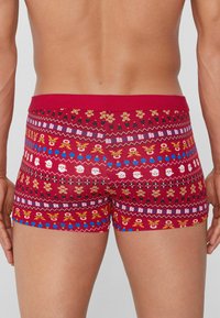 Calzoncillos bóxer rojos con un patrón festivo de caras de Santa Claus, renos y muñecos de jengibre. Tela suave con un ajuste ceñido y cinturilla elástica.