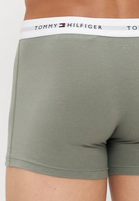 Groene katoenen boxershorts met een witte elastische tailleband waarop het logo "TOMMY HILFIGER" staat, met een gladde textuur en een aansluitend ontwerp.