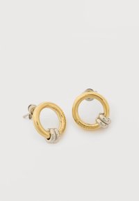 Στρογγυλά σκουλαρίκια καρφάκια σε χρυσό τόνο με δύο μικρούς ασημένιους κρίκους και διακριτική χάραξη Calvin Klein σε λευκό φόντο.