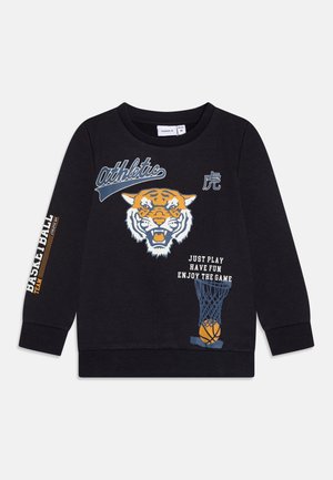 Sudadera negra con un gráfico de tigre, una red de baloncesto y texto. Mangas largas con la palabra "BASKETBALL" impresa en una de ellas. Hecha de tela suave.