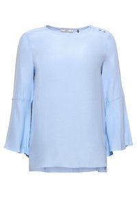 Blouse bleu clair à manches longues avec poignets évasés et détails de boutons sur l'épaule gauche, dotée d'un col rond et d'une coupe décontractée.