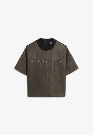 Overmaatse olijfgroene T-shirt van leer, met een gestructureerde zwarte gebreide kraag en decoratieve zilveren studs over de borst.