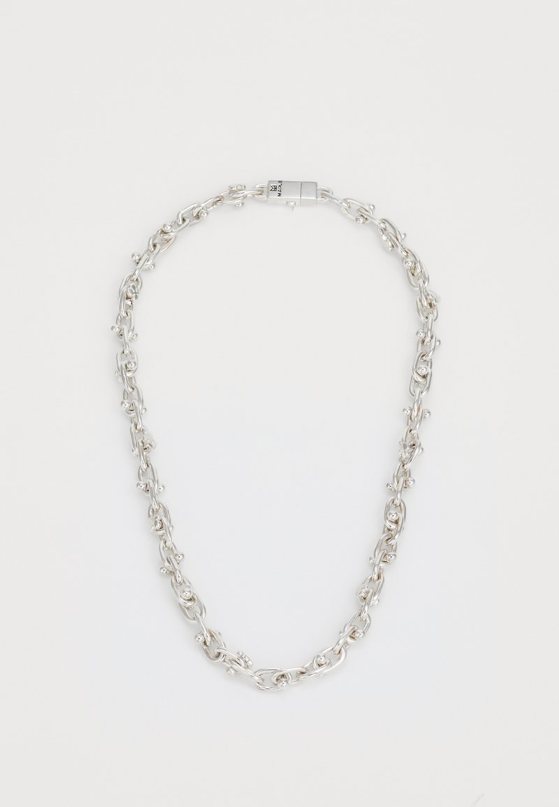 Collar de cadena de plata con pequeñas cuentas redondas espaciadas uniformemente a lo largo de eslabones retorcidos y un cierre rectangular sobre un fondo blanco.