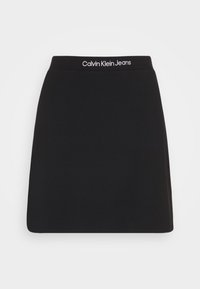 Černá bavlněná sukně s přiléhavým pasem, na kterém se nachází bílé logo "Calvin Klein Jeans". Hladká textura a jednoduchý design.