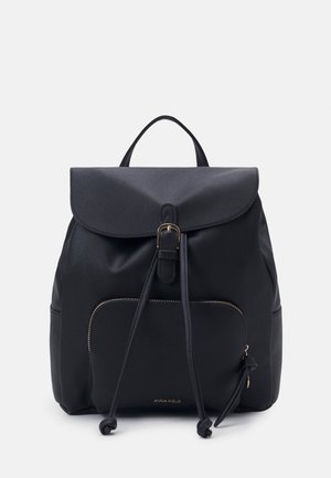 Mochila negra hecha de tela suave con cierre tipo solapa, bolsillo frontal con cremallera, detalle de cordón y acentos en tono dorado.