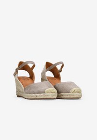 Zapatos de cuña de ante beige con un tacón de yute trenzado, punta redondeada, correa en el tobillo y acento de punta tejido en contraste.