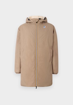 Manteau d'hiver beige à capuche avec fermeture éclair frontale, poignets élastiques, poches latérales et petit logo sur le haut de la poitrine, doublé en polaire crème à l'intérieur de la capuche.