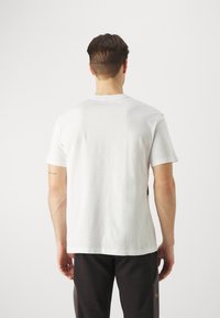 Witte katoenen t-shirt met korte mouwen en een ronde halslijn, met een gladde textuur, standaard pasvorm en een minimalistisch ontwerp.