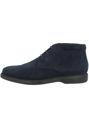 Bottines en daim bleu marine avec un bout arrondi, un laçage et une semelle en caoutchouc noir contrastant. Coutures simples sur la tige.