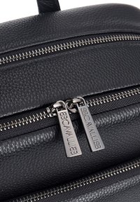 Borsa in pelle nera con due cerniere argento dotate di tiranti con logo, superficie testurizzata e design strutturato. I dettagli includono cuciture fini.