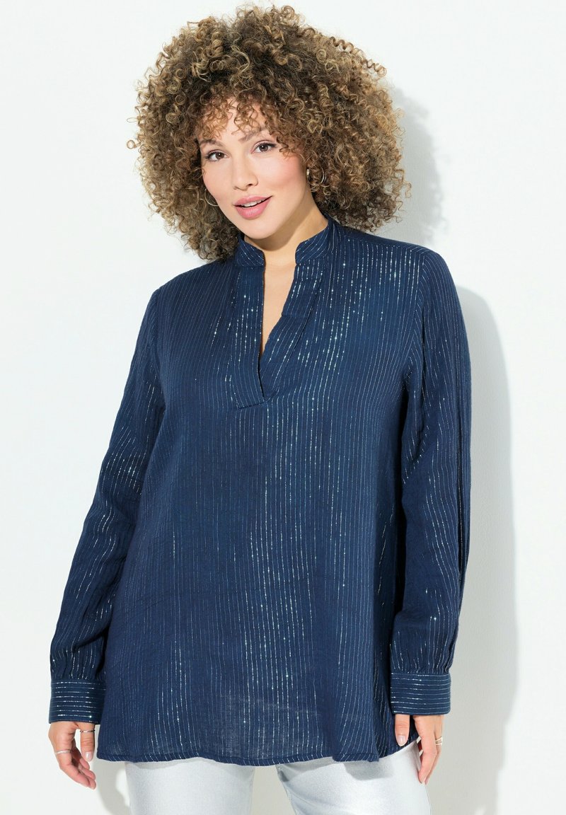 Camicia blu navy con righe verticali, texture leggera, maniche lunghe, colletto rialzato e dettagli di luccichio sottili. Finitura in tessuto liscia.