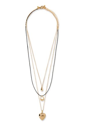 Collane d'oro a strati con cordoncino nero, con un ciondolo a forma di goccia, un pendente a goccia vuoto e un pendente solido a forma di cuore su catene d'oro.