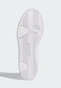 Biely gumový podrážka tenisky s textúrovaným cik-cak vzorom, obklopený okrúhlym akcentom a logom "adidas". Obsahuje oblasti s malými vyvýšenými bodmi.