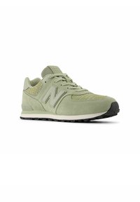 Lichtgroene New Balance sneaker met suède en mesh materialen, een gestructureerd ontwerp, standaard vetersluiting aan de voorkant en een zwart gestipte zool.