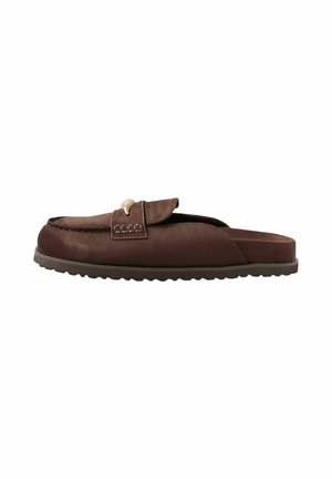 Brun ruskind slip-on loafer med lav, flad gummisål og guldfarvet spænde-detalje på toppen.