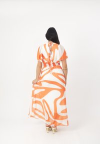 Maxikleid mit orange-weißem abstraktem Muster, kurzen Puffärmeln, gerafftem Taillenbereich und einer Bindeschließe im Rücken. Luftiger, leichter Stoff.